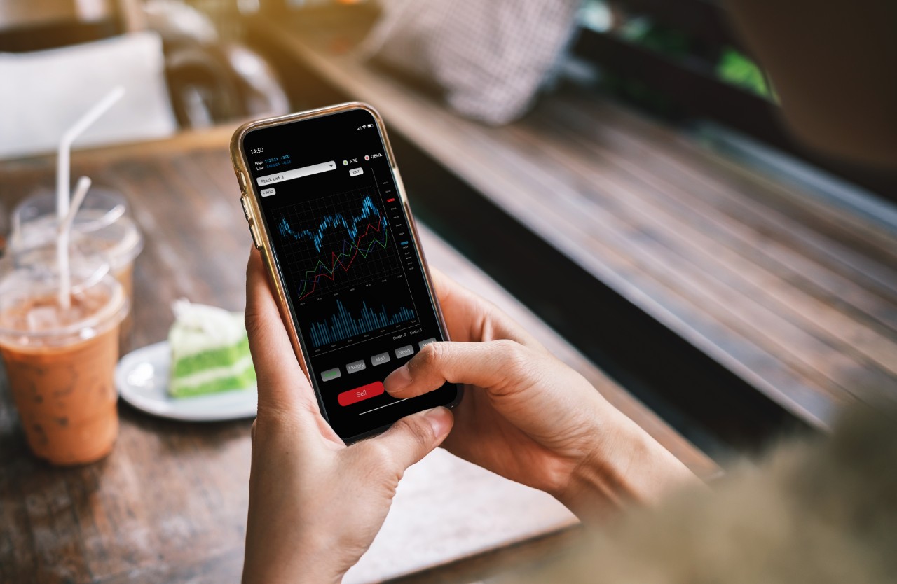The younger generation is using laptops, phones and tablets with stock status information or stock charts. Stock trend chart graph analysis. Business concept The younger generation is using laptops, phones and tablets with stock status information or stock charts. Stock trend chart graph analysis. Business concept